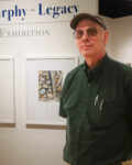 Ted Murphy standing in front of Gallery wall